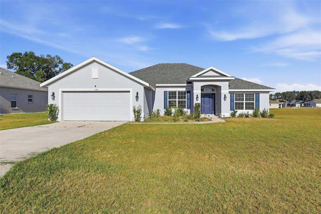 A kitchen features dark wood cabinets, granite countertops, stainless steel appliances, and light tile flooring — 9144 SE 47TH COURT ROAD, OCALA, FL