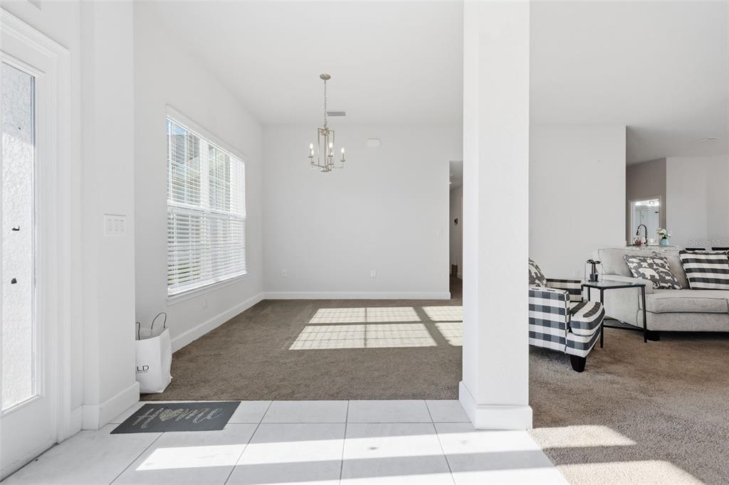 A kitchen with dark cabinets, granite countertops, and a breakfast bar overlooking a carpeted room — 9144 SE 47TH COURT ROAD, OCALA, FL