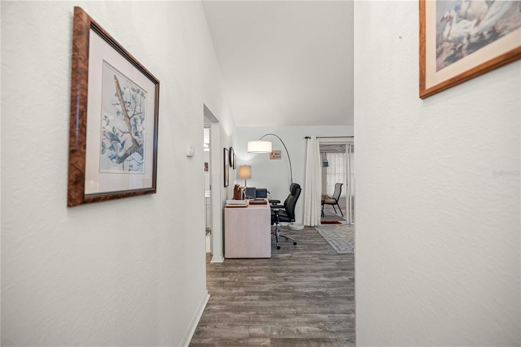 A hallway leads into a home office featuring a desk, chair, and floor lamp — 13732 SE 88TH COURT, SUMMERFIELD, FL