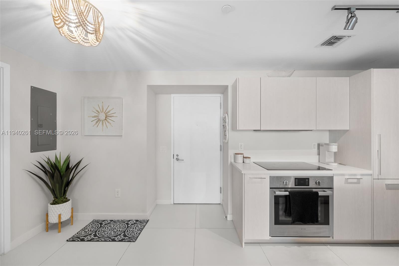 A modern kitchen features white cabinetry, stainless steel appliances, and a light-colored tile floor — 501 NE 31st St # 1503, Miami FL 33137, MIAMI, FL