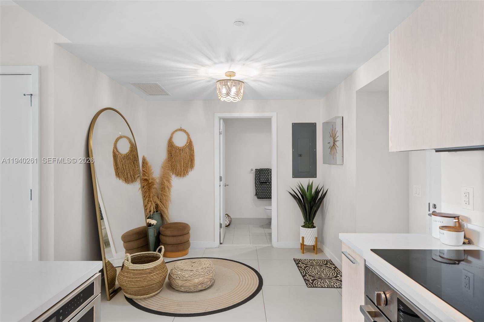 A bright kitchen area features a large floor mirror, circular rug, and doorway to a bathroom — 501 NE 31st St # 1503, Miami FL 33137, MIAMI, FL