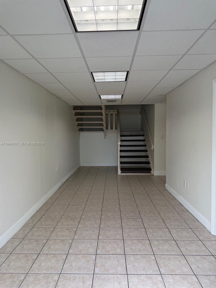 An interior room features beige tile flooring, light-colored walls, and a staircase leading upward — 16155 SW 117th Ave # B2, Miami FL 33177, MIAMI, FL