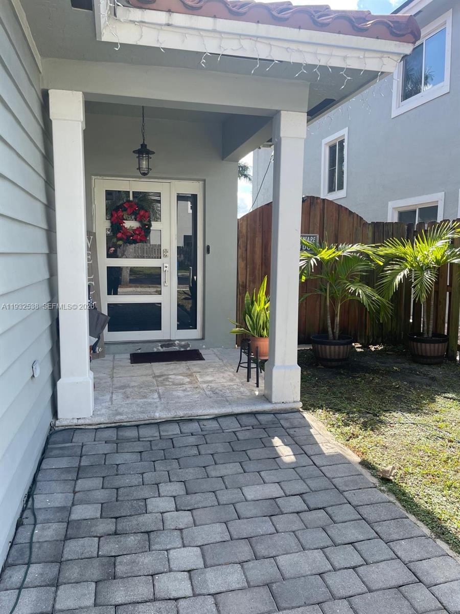 A paved walkway leads to a covered porch with a glass-paneled front door — 3134 NE 3rd Dr, Homestead FL 33033, HOMESTEAD, FL
