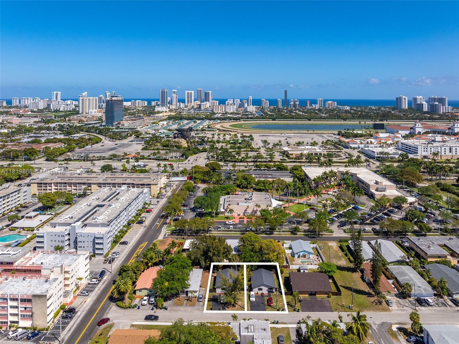 An aerial view shows two adjacent residential lots outlined in white near a city skyline — 311 SE 3rd Ave, Hallandale Beach FL 33009, HALLANDALE BEACH, FL