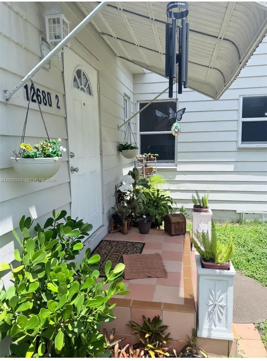 A front porch with a tiled floor, potted plants, and a white door — 12680 NE 3rd Ave # B, North Miami FL 33161, NORTH MIAMI, FL