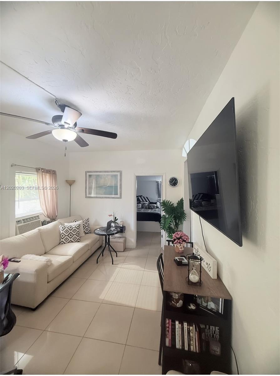 A living room features a white sofa, a wall-mounted television, and tile flooring — 12680 NE 3rd Ave # B, North Miami FL 33161, NORTH MIAMI, FL