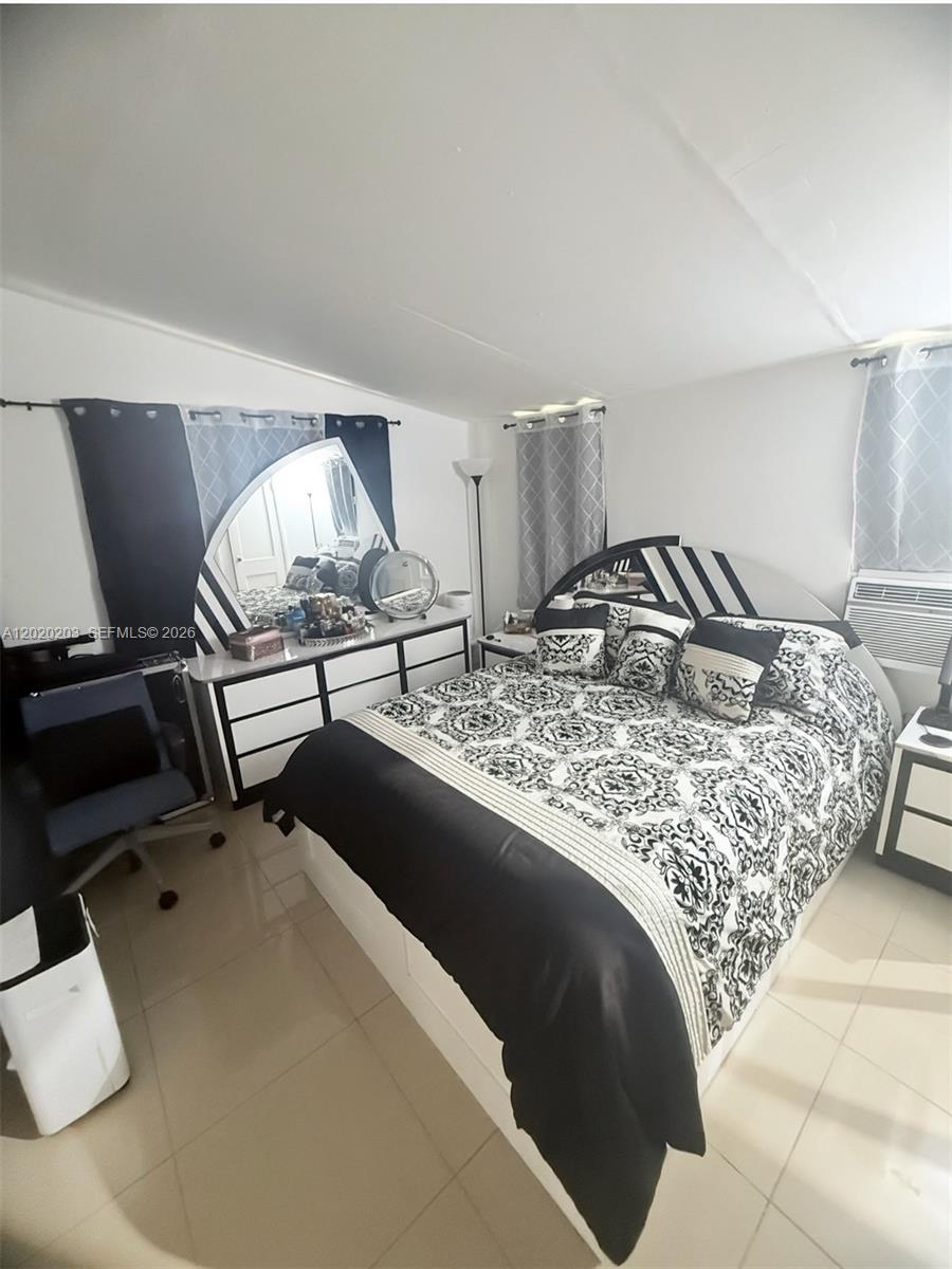 A bedroom features a black and white patterned bed, matching dresser, and tiled flooring — 12680 NE 3rd Ave # B, North Miami FL 33161, NORTH MIAMI, FL