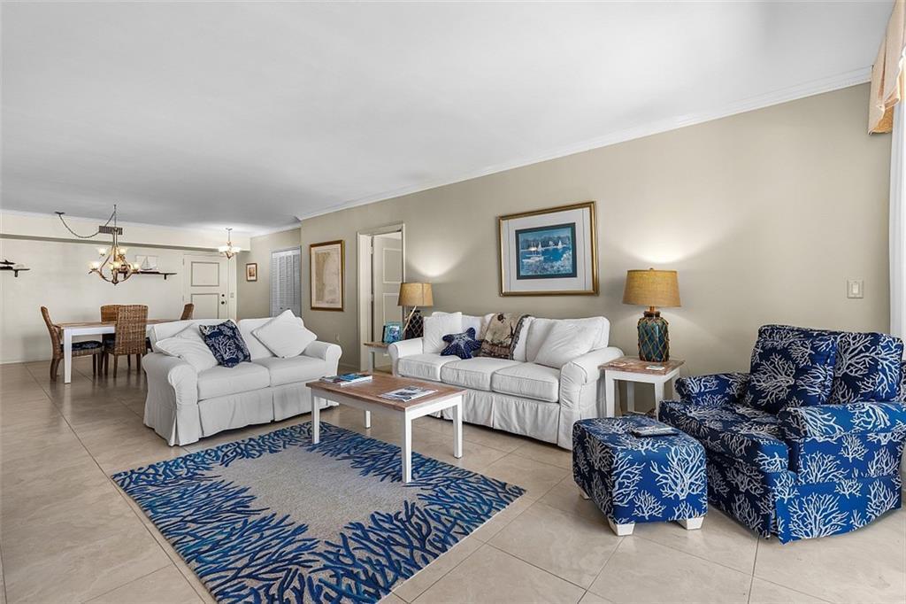 A living room features white sofas, a blue coral-patterned armchair, and a matching area rug — VERO BEACH, FL