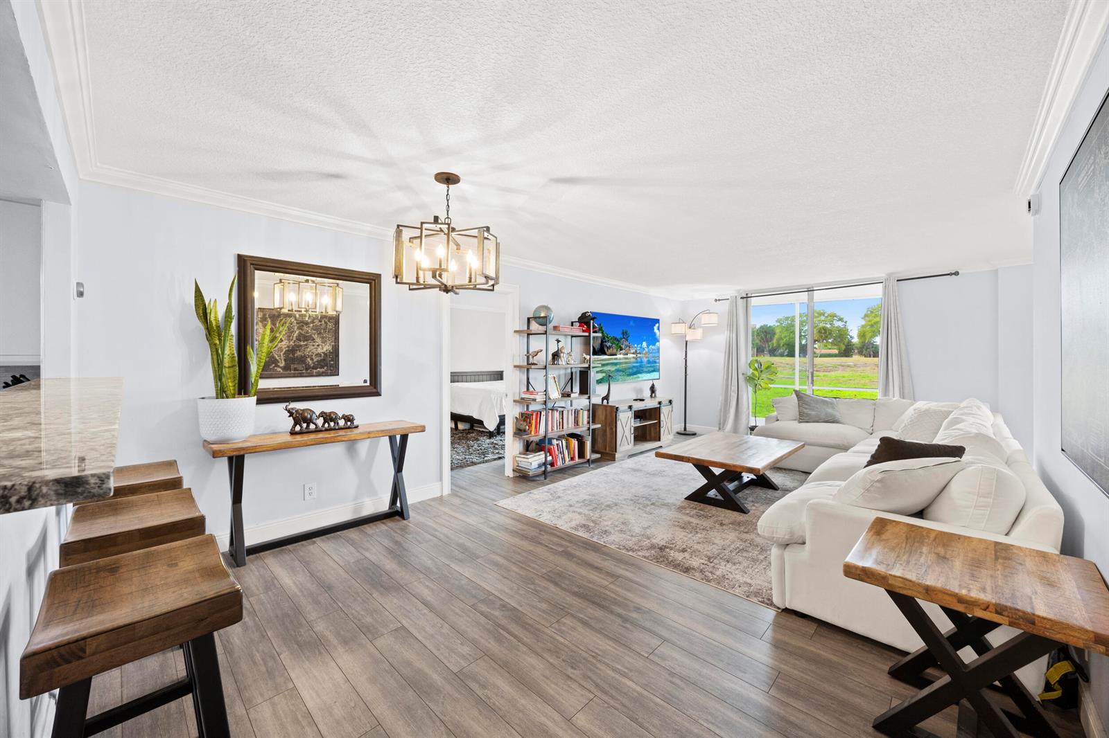 A living room features wood-look flooring, a white sectional sofa, and a dining area — 5301 NW 2nd Avenue # 1010, Boca Raton FL 33487, BOCA RATON, FL