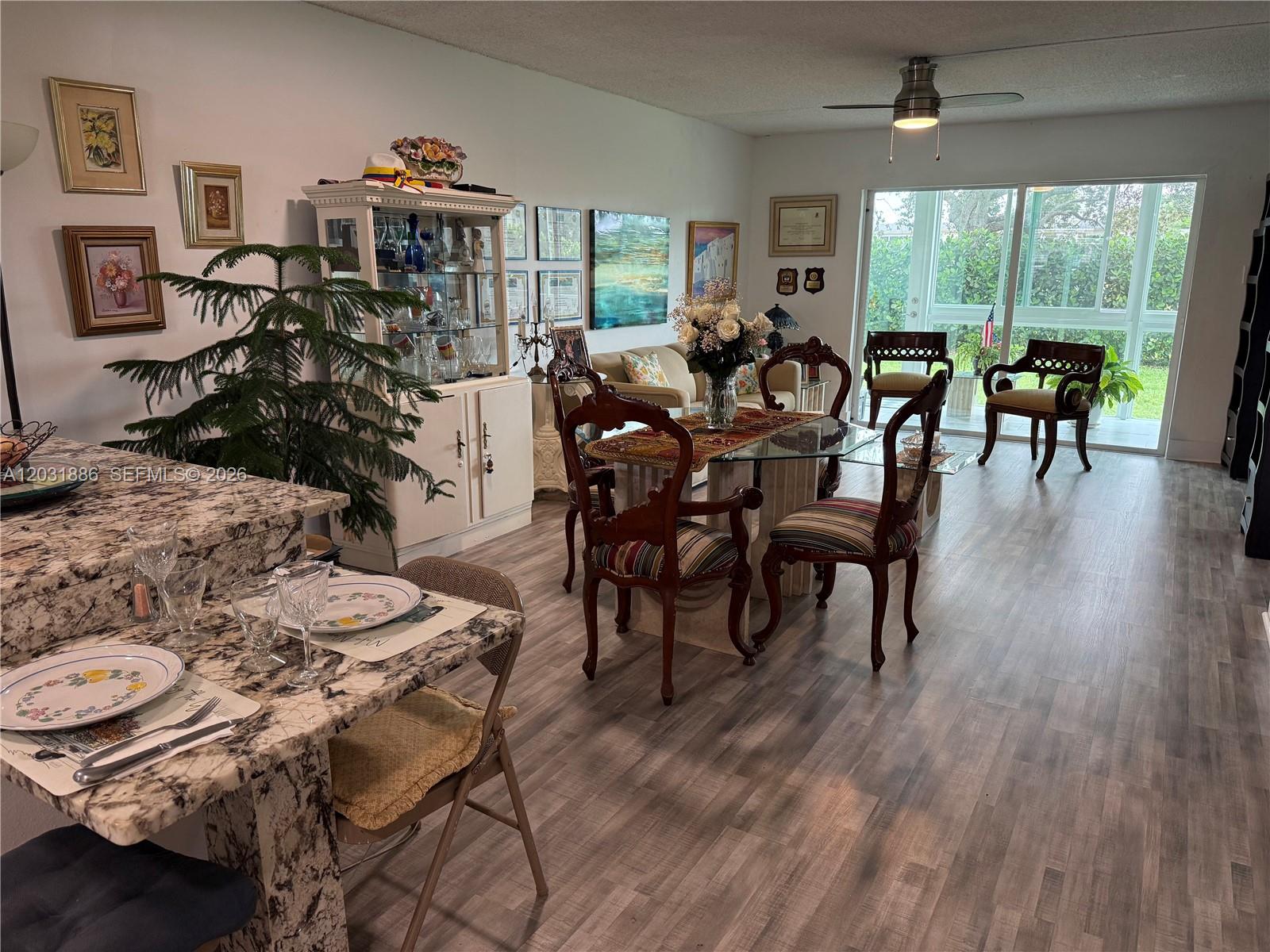 A dining area features a glass table, ornate chairs, a china cabinet, and marble counters — 600 NW 77th Ave # 108, Margate FL 33063, MARGATE, FL