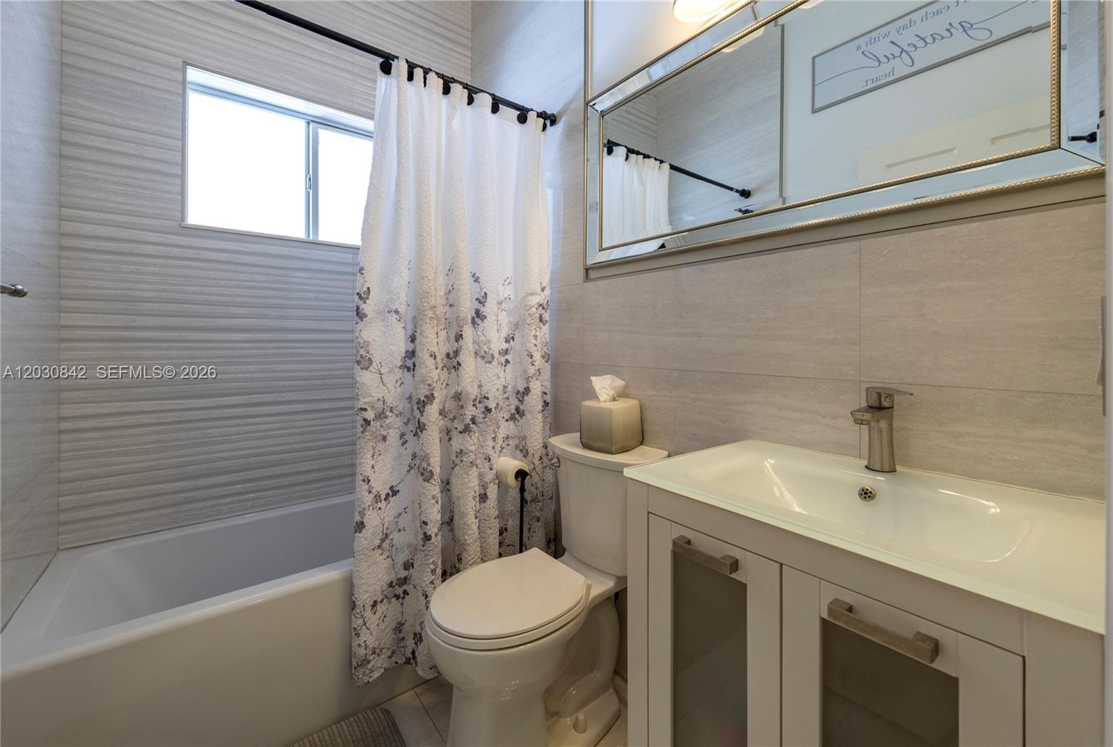 A bathroom features a white tub, a floral shower curtain, a toilet, and a vanity — 3073 SW 140th Ave # 3073, Miramar FL 33027, MIRAMAR, FL
