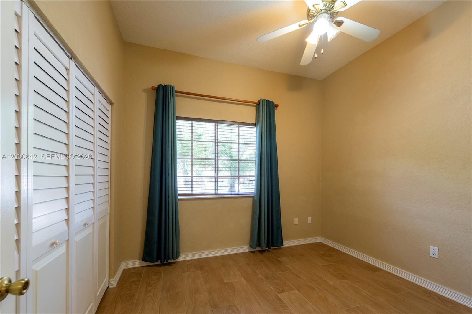This room features light wood-look flooring, beige walls, a ceiling fan, and a window — 3073 SW 140th Ave # 3073, Miramar FL 33027, MIRAMAR, FL
