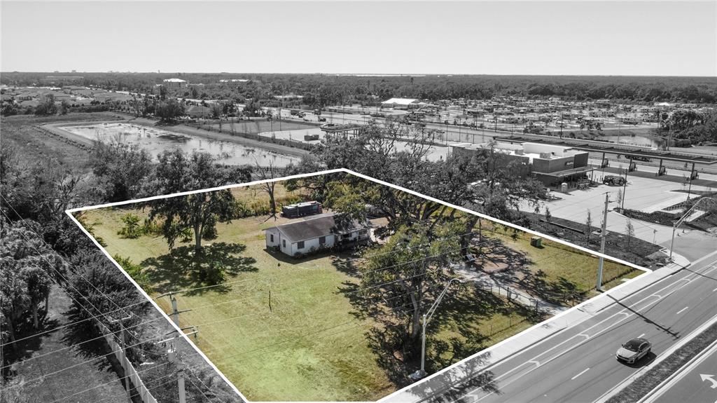 An aerial view shows a single-story house on a large, grassy lot near a road — 2519 MOCCASIN WALLOW ROAD, PALMETTO, FL