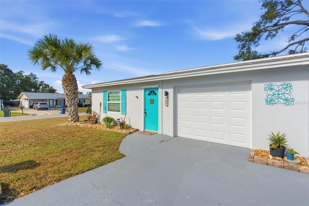 A single-story house exterior features a turquoise front door, white garage door, and palm tree — 2227-2229 MONTCLAIR DRIVE UNIT 1&2, SARASOTA, FL