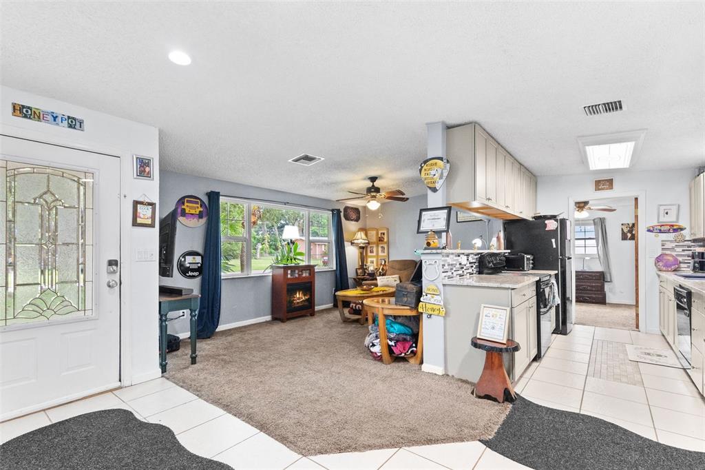 A single-story house with a blue front door, a large tree, and a paved driveway — 1807 CARLTON DRIVE, CLEARWATER, FL