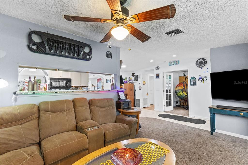A home office features a colorful hanging chair, a white desk, and a ceiling fan — 1807 CARLTON DRIVE, CLEARWATER, FL