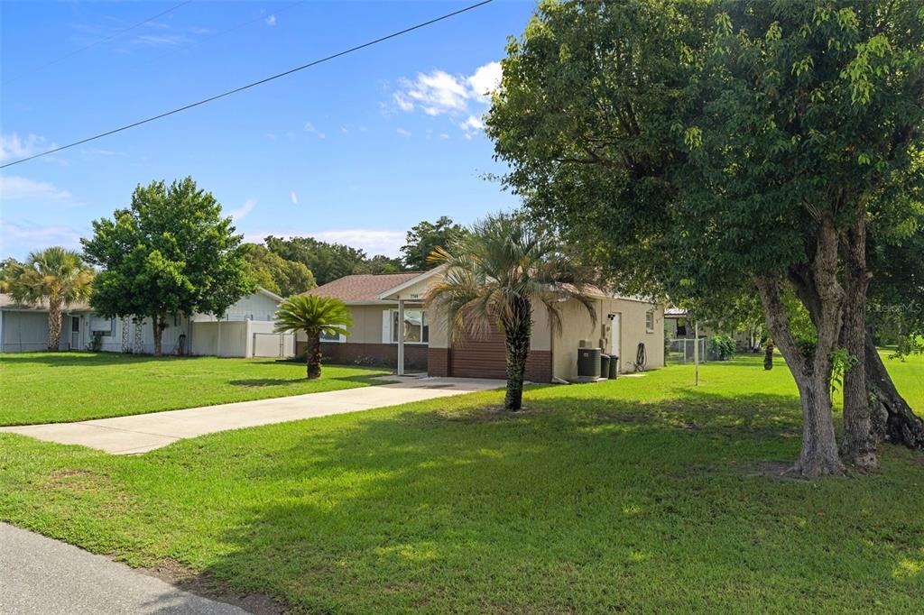 A single-story house with a concrete driveway and a large lawn under a blue sky — 7740 W SOLAR PLACE, HOMOSASSA, FL