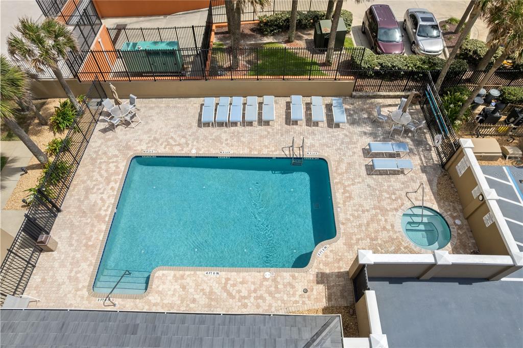 An aerial view shows a rectangular swimming pool, a hot tub, and lounge chairs — 2855 S ATLANTIC AVENUE UNIT 201, DAYTONA BEACH, FL