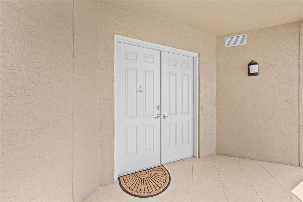 A white double door with a small number plate sits on a tiled porch — 2855 S ATLANTIC AVENUE UNIT 201, DAYTONA BEACH, FL