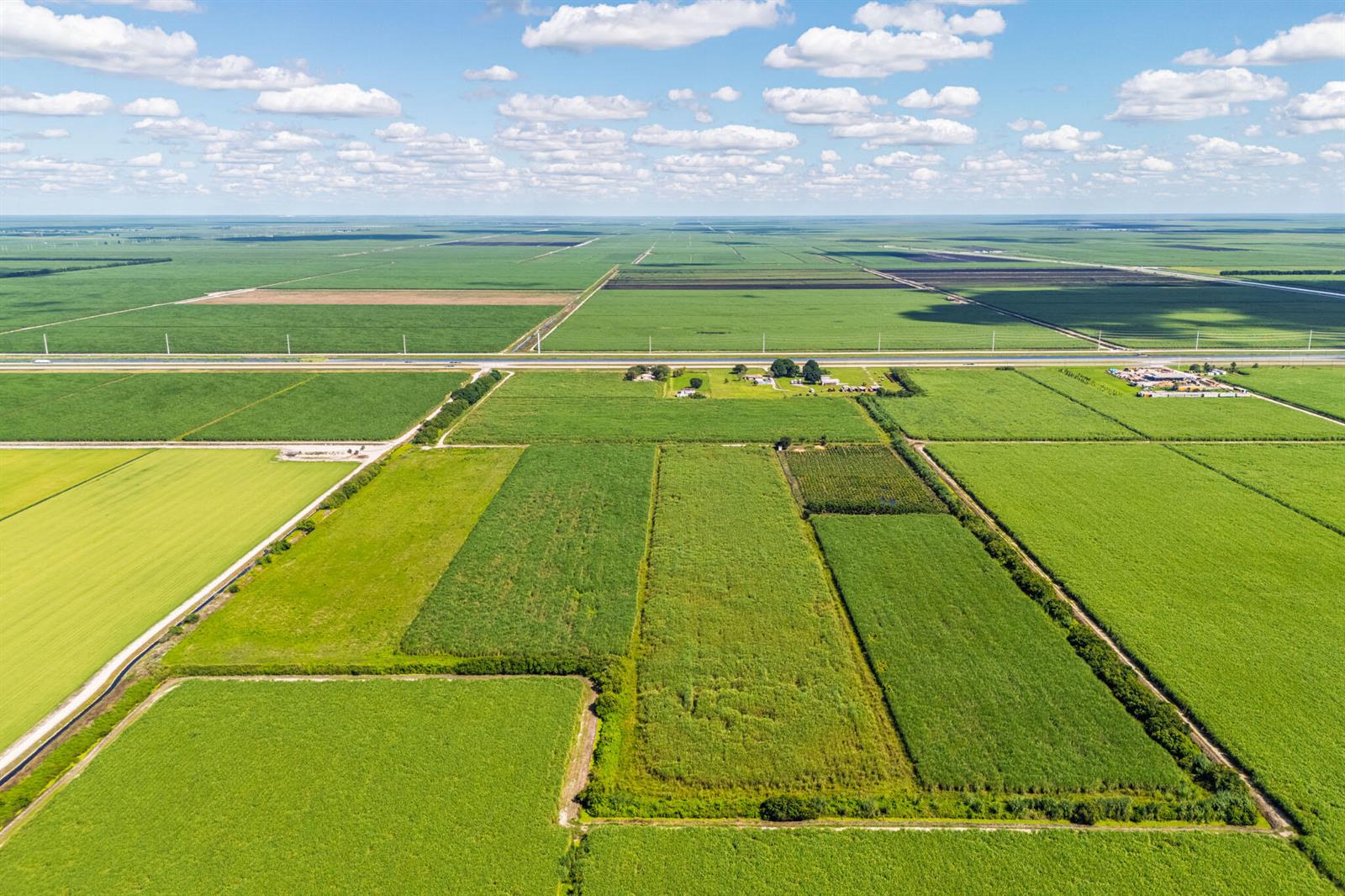 An aerial view shows a large expanse of agricultural fields divided by roads and canals — 0 Highway 27, South Bay FL 33493, SOUTH BAY, FL