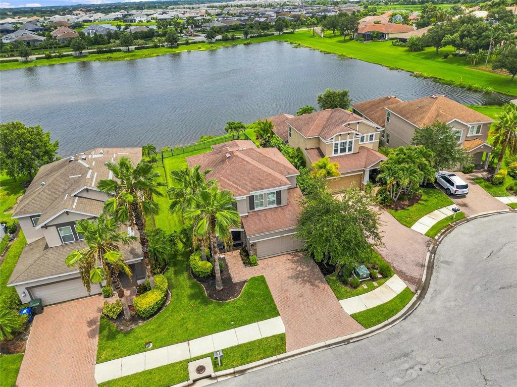 An aerial view of suburban houses with tile roofs situated along a lake — 8478 NANDINA DRIVE, SARASOTA, FL