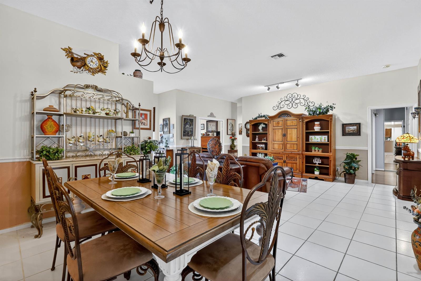 A dining area with a wooden table and chairs sits in front of a living room — 3747 Spring Crest Court, Lake Worth FL 33467, LAKE WORTH, FL