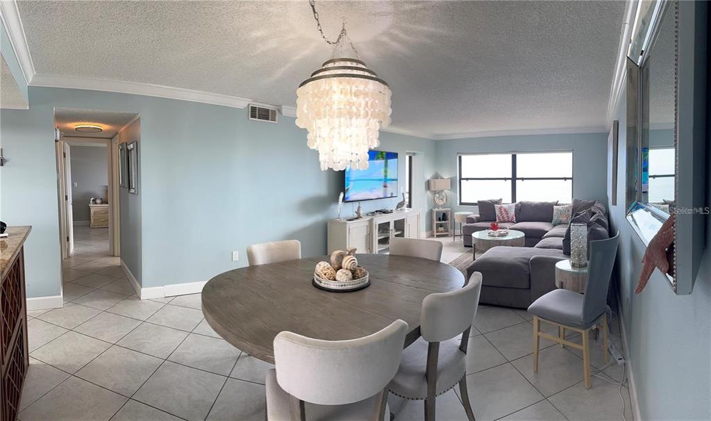 An outdoor balcony features a table with chairs, a dark door, and tiled flooring — 1270 GULF BOULEVARD UNIT 1206, CLEARWATER BEACH, FL