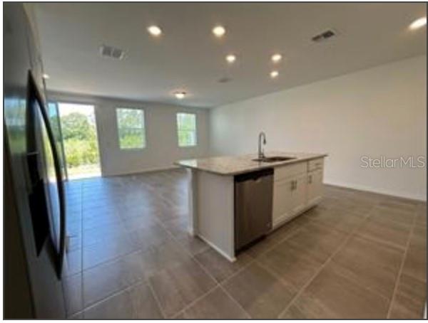 A kitchen island with a dishwasher sits in an open-concept room with tile flooring — 4325 EAGLE TRAIL BEND, ST CLOUD, FL