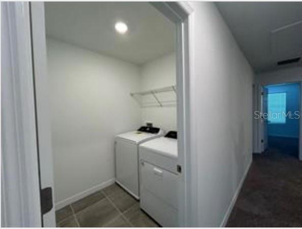 A laundry room with white appliances and a wire shelf, viewed from a hallway — 4325 EAGLE TRAIL BEND, ST CLOUD, FL