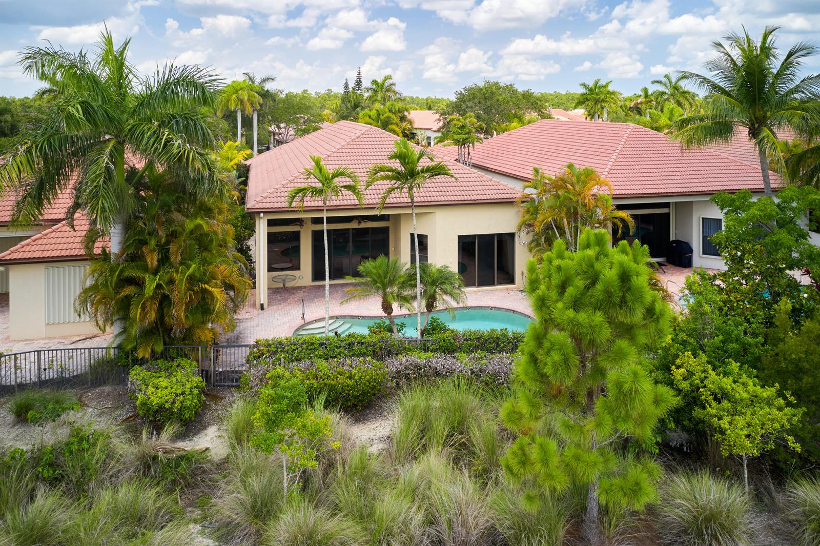 An aerial view of a house with a tile roof, swimming pool, and tropical landscaping — 6490 Sparrow Hawk Drive, West Palm Beach FL 33412, WEST PALM BEACH, FL