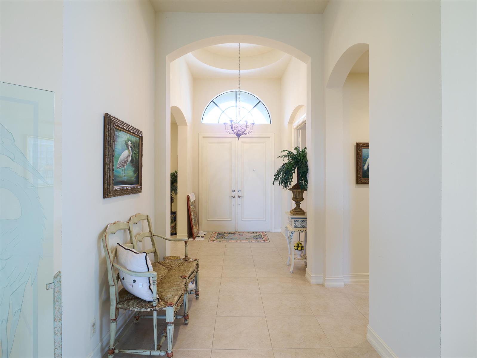 A bright foyer features a double door entrance, arched ceilings, tile flooring, and decorative furniture — 6490 Sparrow Hawk Drive, West Palm Beach FL 33412, WEST PALM BEACH, FL