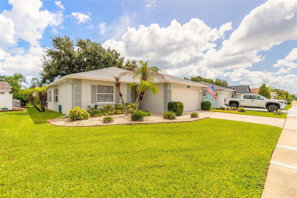 A single-story house with a light-colored exterior, a two-car garage, and a manicured front lawn — 656 MIDDLEBURY LOOP, NEW SMYRNA BEACH, FL