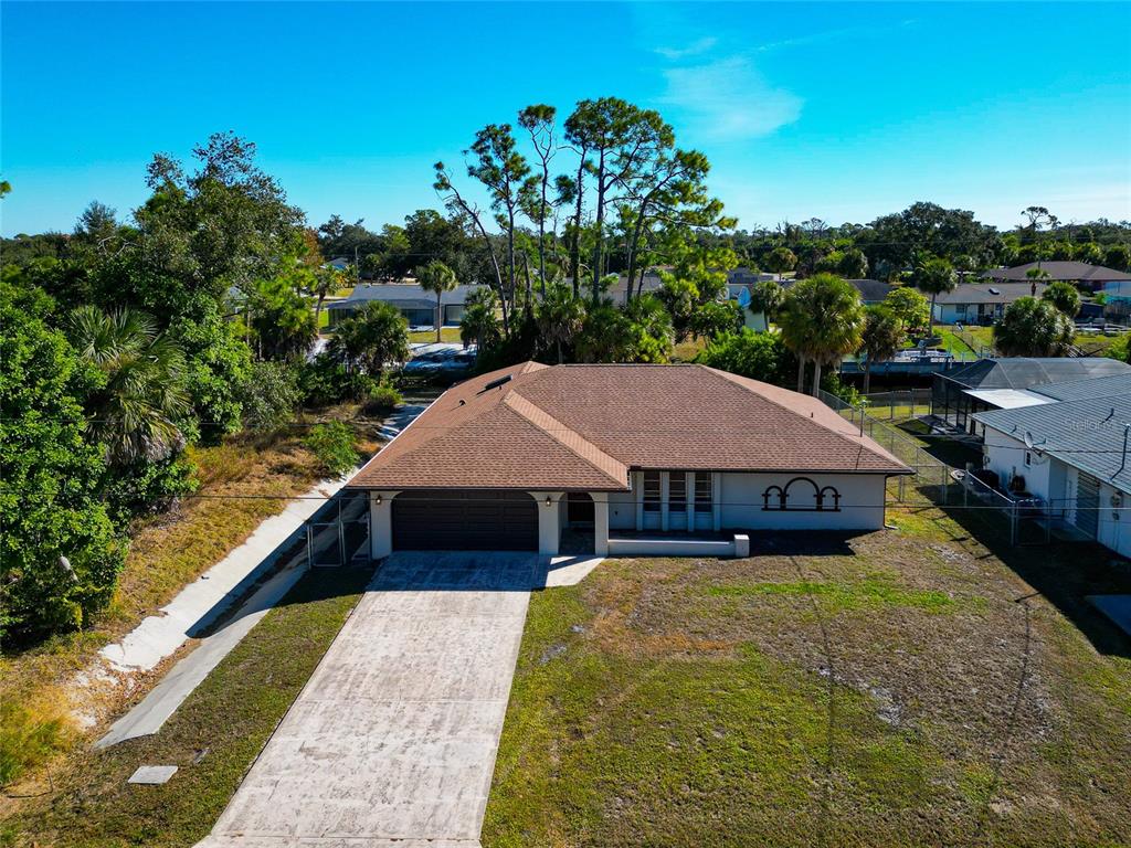 An aerial view of a single-story house with a brown roof and a concrete driveway — 2176 BARKSDALE STREET, PORT CHARLOTTE, FL