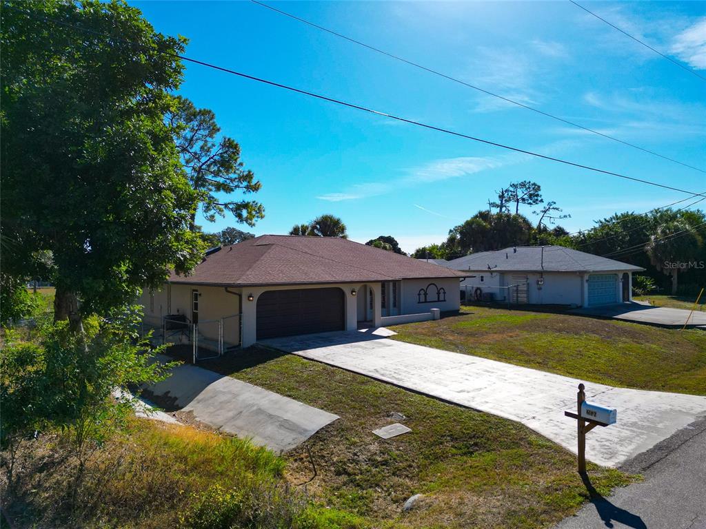 An exterior view of a single-story house with a brown roof and a concrete driveway — 2176 BARKSDALE STREET, PORT CHARLOTTE, FL