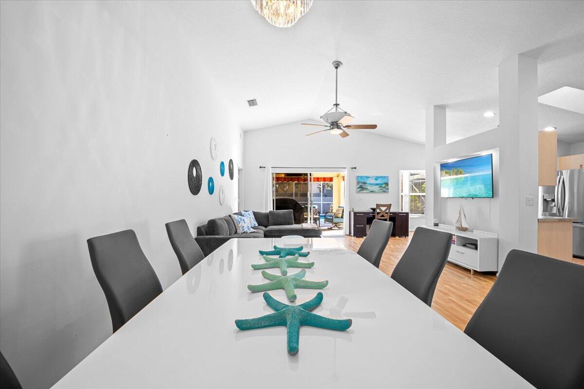 A dining area with a white table and chairs opens into a living room space — 7534 Ironbridge Circle, Delray Beach FL 33446, DELRAY BEACH, FL