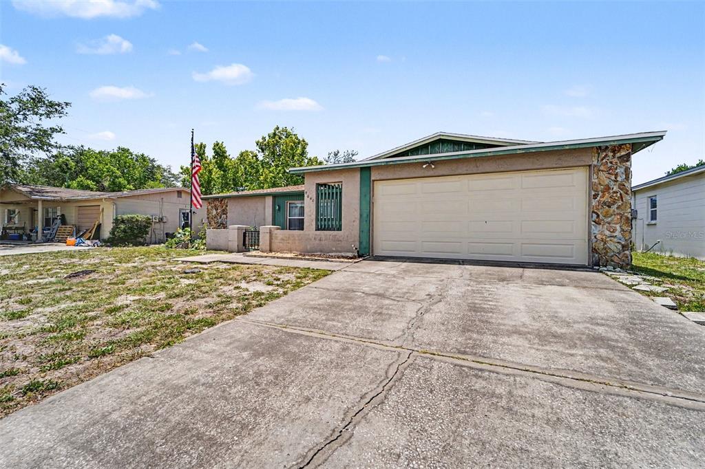 A single-story house with a two-car garage, stone accents, and a concrete driveway — 8040 SAYBROOK DRIVE, PORT RICHEY, FL