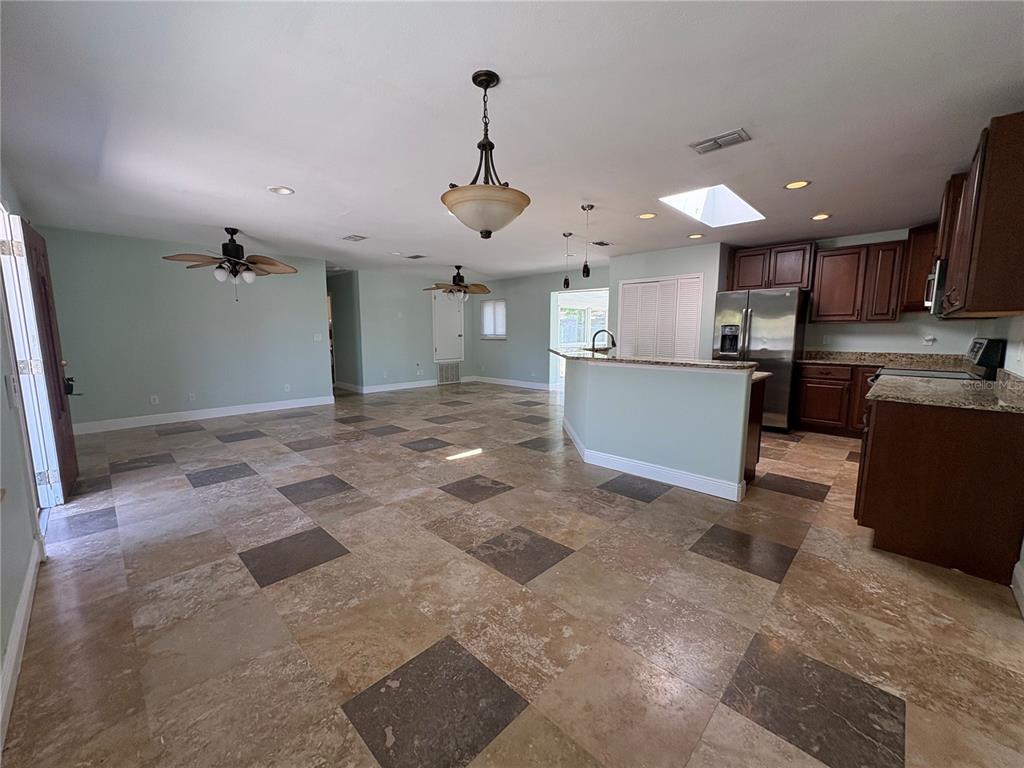An open-concept kitchen and living area features tile flooring, dark wood cabinets, and a skylight — 218 LEWIS BOULEVARD SE, ST PETERSBURG, FL