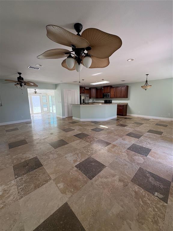 A spacious kitchen and living area features tile flooring, a large island, and ceiling fans — 218 LEWIS BOULEVARD SE, ST PETERSBURG, FL
