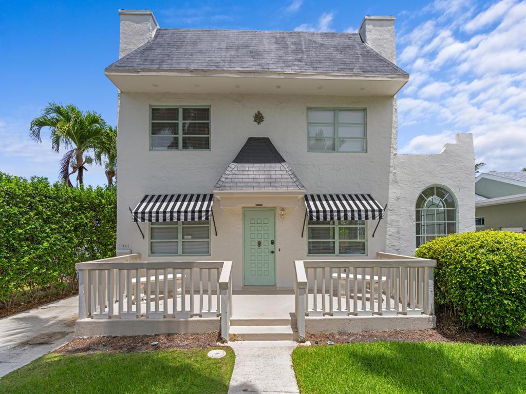 A two-story white house features a light green front door, striped awnings, and a porch — 422 N Lakeside Drive, FL 33460, FL