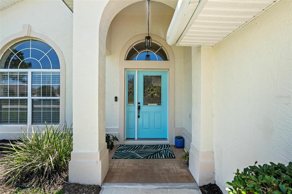 A bright blue front door with a glass insert sits under an arched entryway — 3 LEWIS DRIVE, PALM COAST, FL
