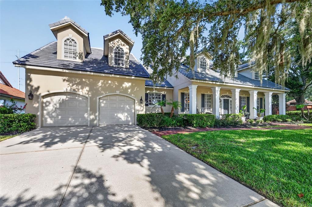 A two-story house with a two-car garage, dormer windows, and a columned front porch — 900 BRIGHTWATER CIRCLE, MAITLAND, FL
