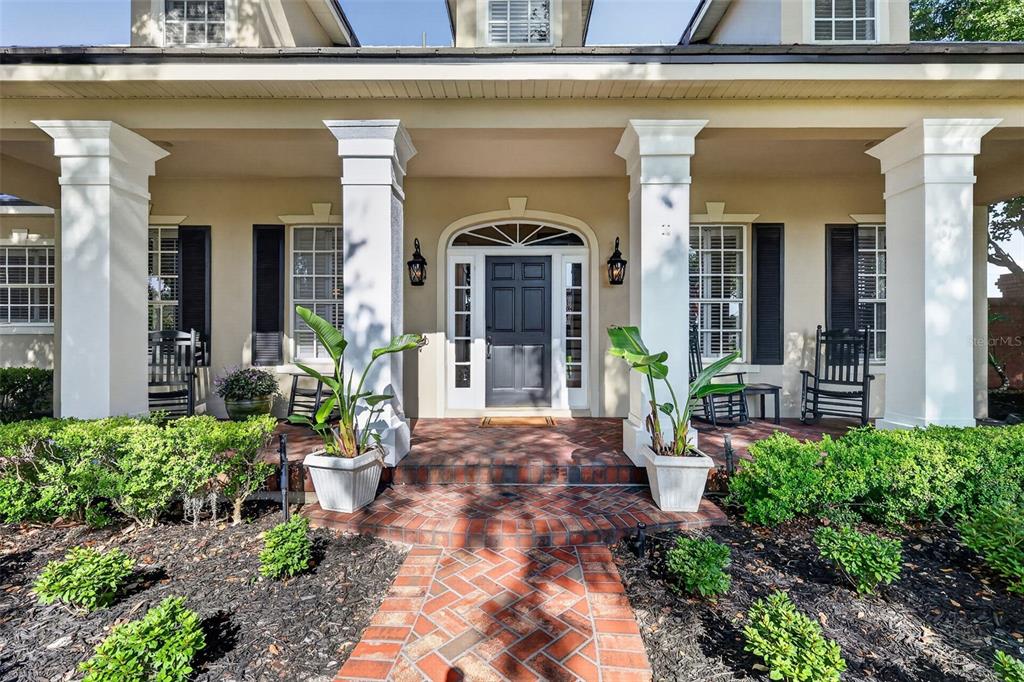 A front porch with white columns, a brick walkway, and a dark front door — 900 BRIGHTWATER CIRCLE, MAITLAND, FL