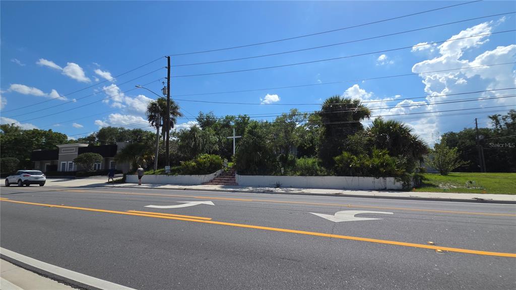 A white retaining wall with stairs leads to a cross on a grassy, tree-filled lot — 236 N AMELIA AVENUE, DELAND, FL