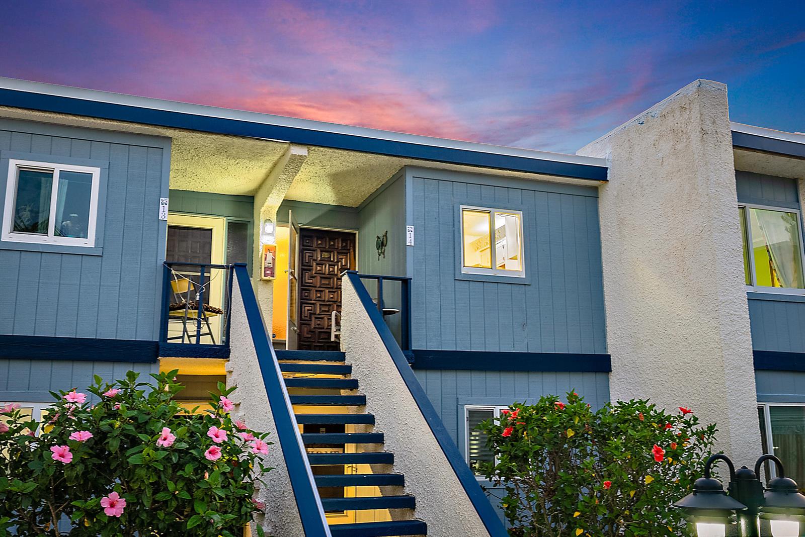 A two-story blue apartment building features an exterior staircase leading to two upper-level unit doors — 1561 NE 12th Terrace # C14, Jensen Beach FL 34957, JENSEN BEACH, FL
