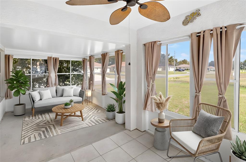 A sunroom features tile flooring, a ceiling fan, a sofa on a rug, and windows — 4849 NW 46TH AVENUE, OCALA, FL