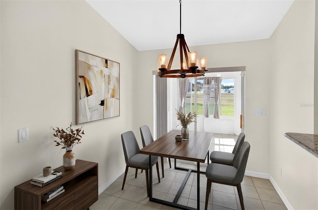 A dining area features a wooden table, four gray chairs, and a rustic chandelier — 4849 NW 46TH AVENUE, OCALA, FL