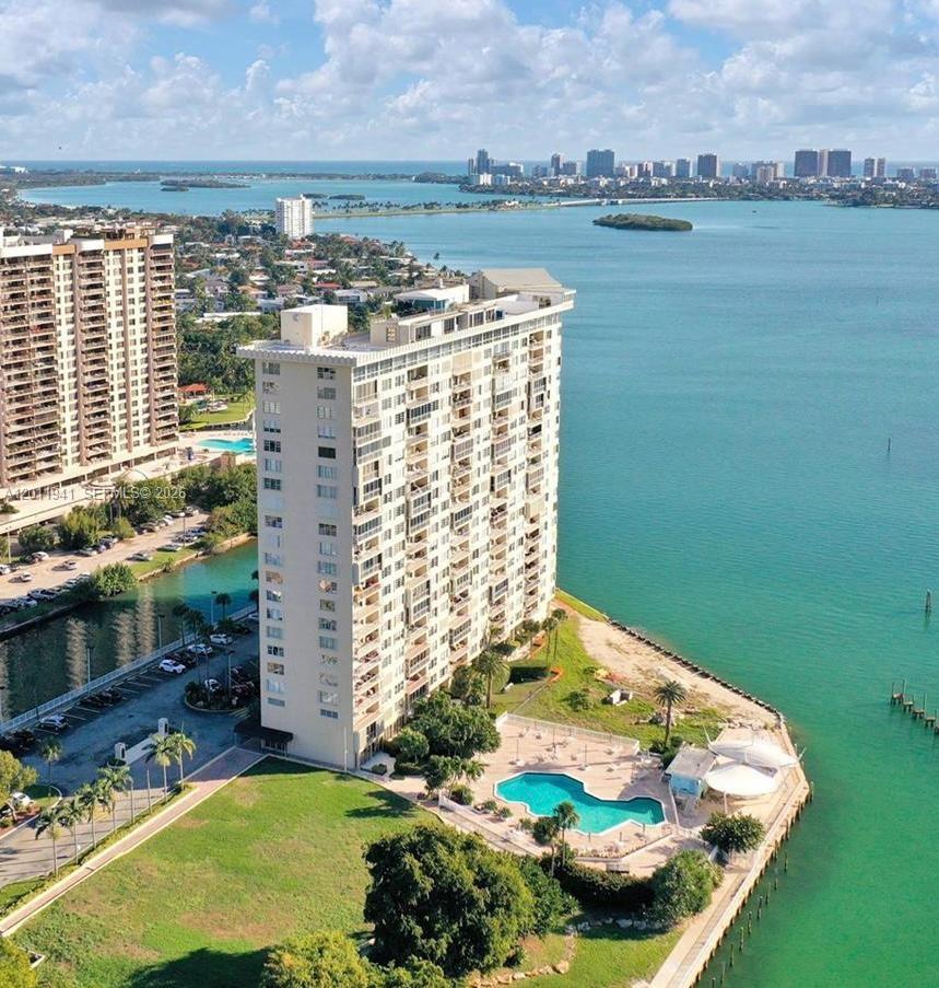 An aerial view of a tall waterfront apartment building with a swimming pool and parking — 11111 Biscayne Blvd # 2H, Miami FL 33181, MIAMI, FL