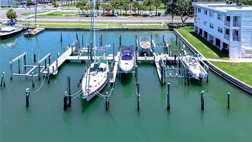 An aerial view of a marina with several boats docked alongside a multi-story apartment building — 340 PINELLAS BAYWAY S UNIT 304, ST PETERSBURG, FL