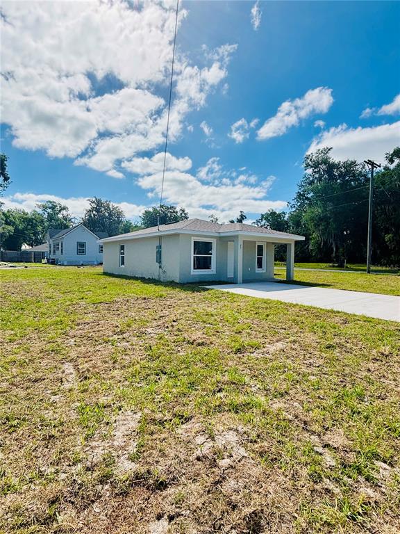 A single-story light gray house with a covered porch sits on a grassy lot — 25 PALMETTO AVENUE S, FORT MEADE, FL