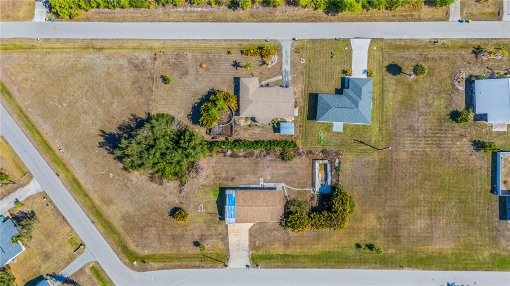 An aerial view shows three houses on large lots with driveways and surrounding grassy yards — 11131 3RD AVENUE, PUNTA GORDA, FL